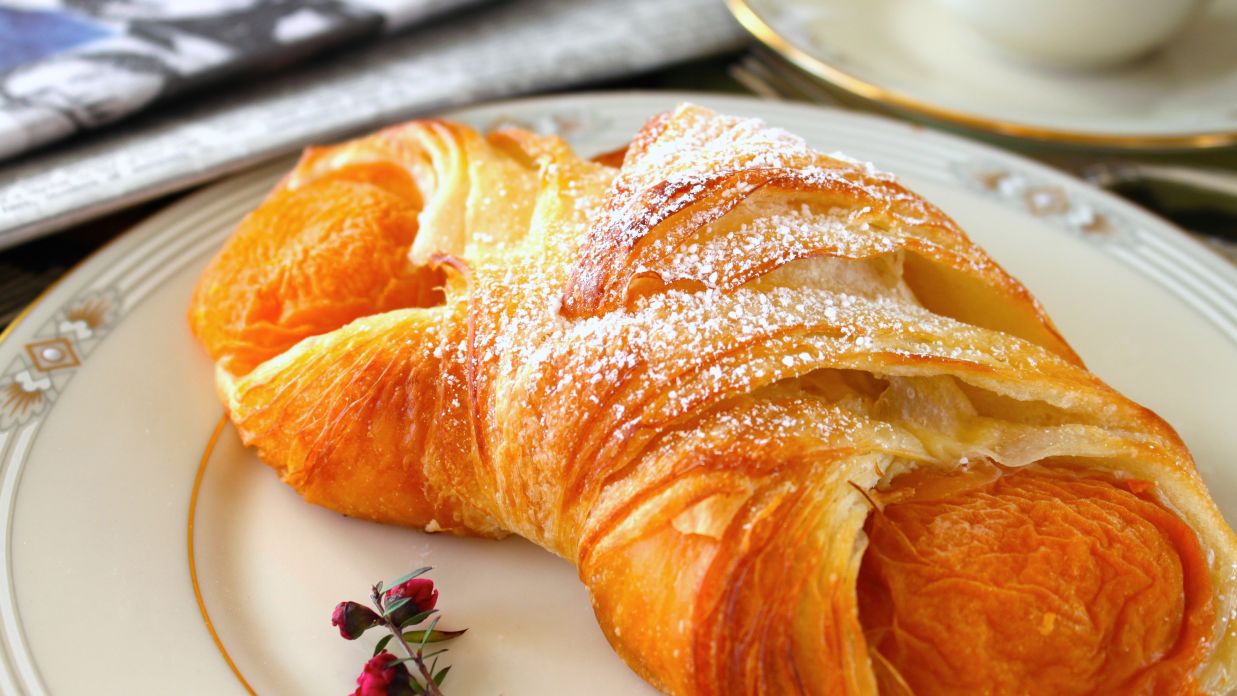 croissant with powered sugar kept on a plate