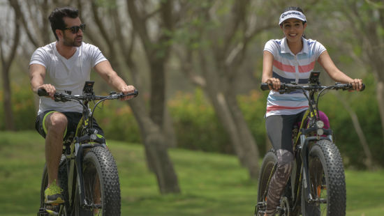 a couple cycling amidst lush green lawns