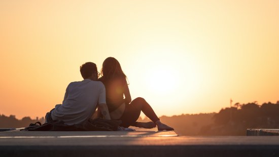 a couple sitting together during sunset