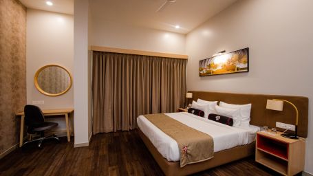 a suite room with king size bed, work desk and other room amenities - Mastiff Hotel, Ankleshwar