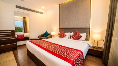 A captivating scene showcasing a cozy bedroom with a luxurious bed, a stylish mirror and warm ambient lighting | The Terrace Business Hotel