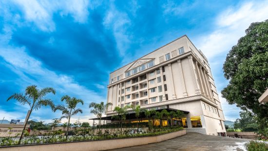 facade of a hotel building with blue sky as the  backdrop - Mastiff Grand - The Sia Palace Suites & Banquets, Khopoli