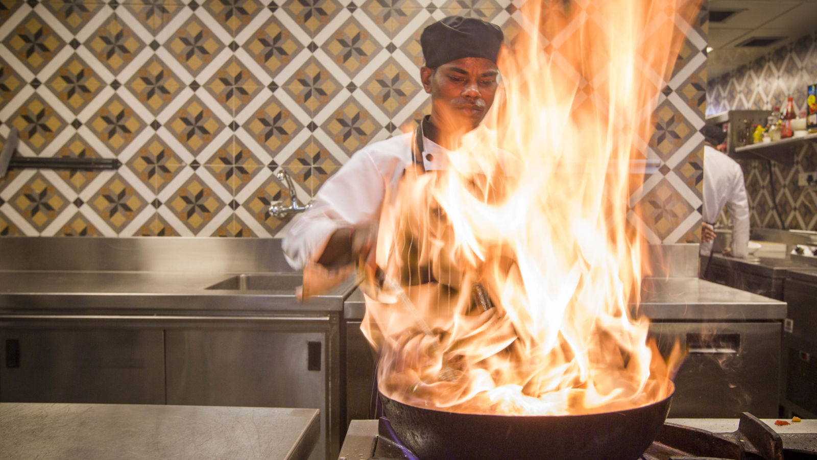 Chef performing a flambe in kitchen