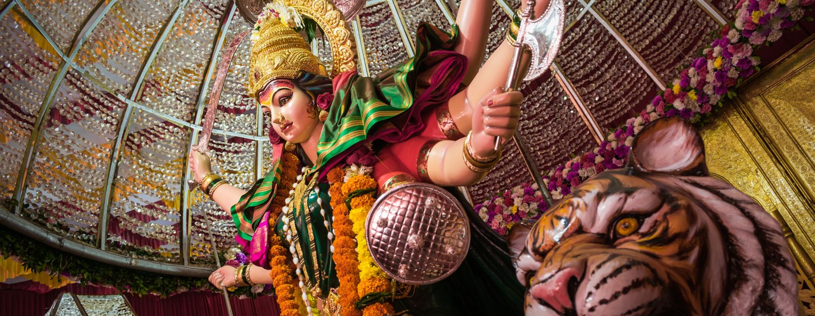 an idol of goddess durga and a tiger inside a temple