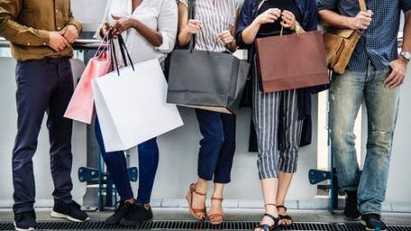 people standing with shopping bags in their hands