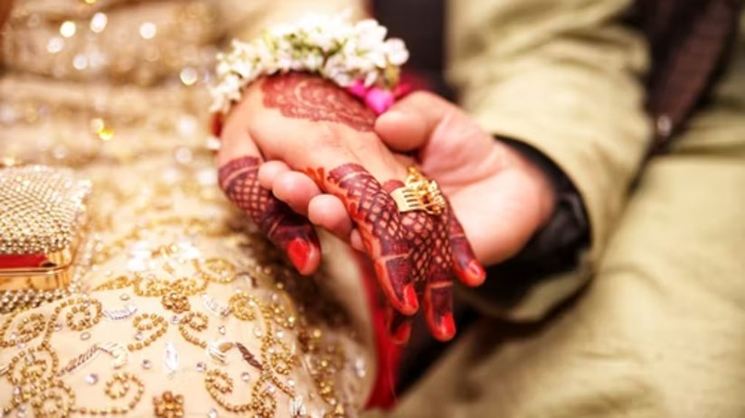 bride and groom holding hands showing wedding ring