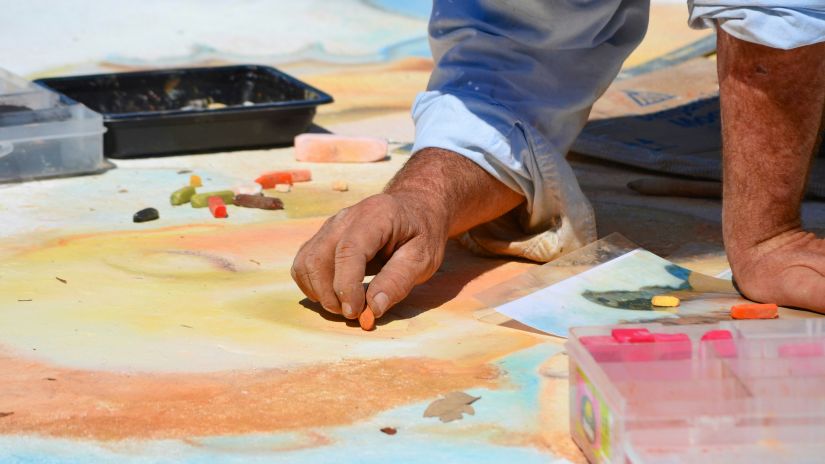 a person in white dress painting on white paper