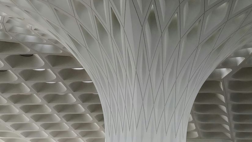 a close up shot of the textured roof with lights lit inside the hotel insides Mumbai Airport Terminal 2