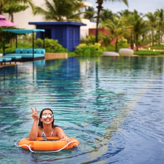 Woman floating on a swimming pool with the help a lifebuoy