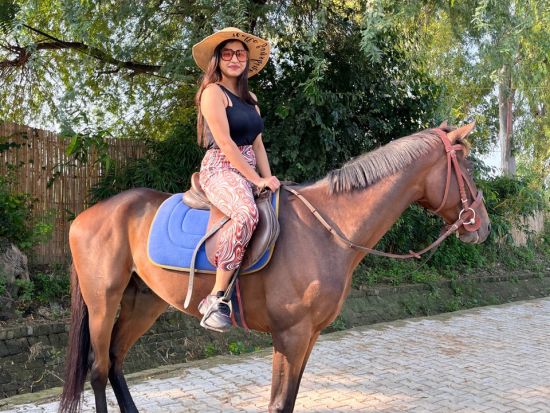 A woman riding on a horse at Themis Mudhouse - A Nature's Retreat Resort & Wellness