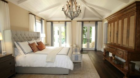 a bedroom with a large bed and a chandelier on the ceiling