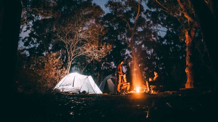 an image of a few people camping under a starlit sky