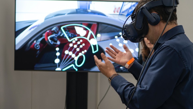 Man using a virtual reality headset with a monitor in the background