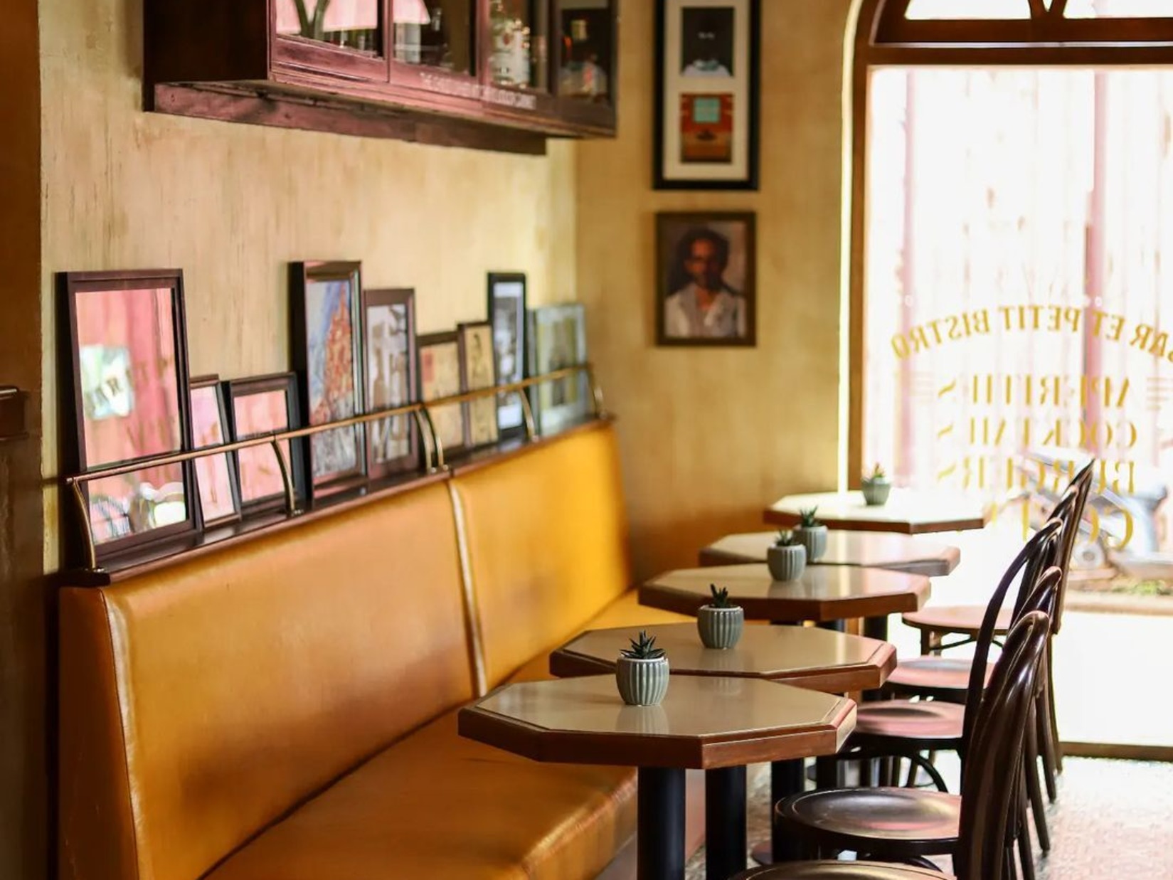 Tables and seaters arranged in warm ambience with a wall decked with decors at Outpost