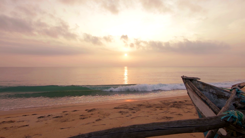 view of a beach with sun setting in the horizon