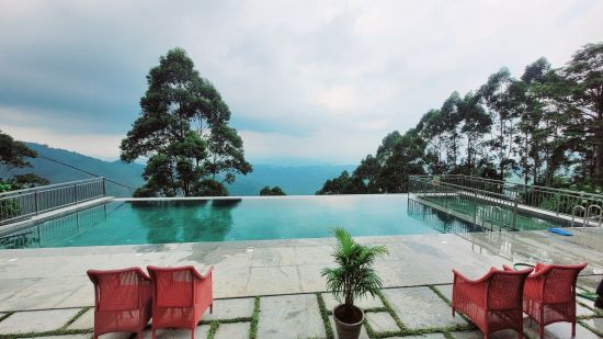 An eye level view of the Infinity Pool Swimming Pool with chair on the sides.