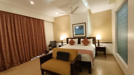 Inside view of Studio Room with Garden with a cosy bed and a sofa at Kyriad Prestige Calangute, Goa