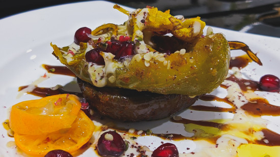 a dish garnished with pomegranate and sesame seeds