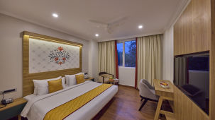 view of a king size bed facing the TV offered at the suite - Golden Tulip, Tirupati