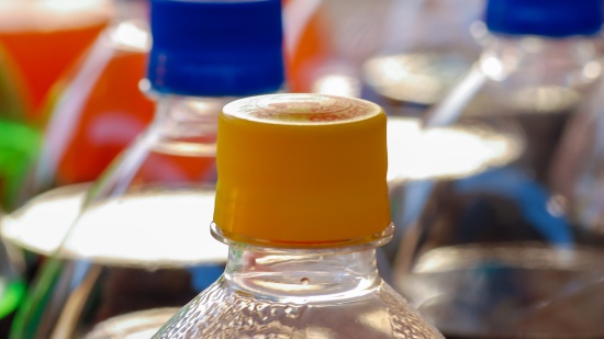 a closeup view of few plastic bottles stacked together with blue and yellow caps