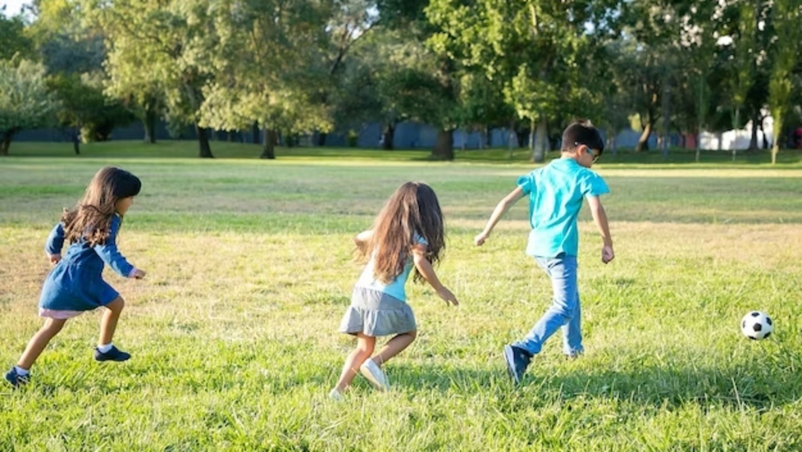 group-active-kids-playing-football-grass-city-park-full-length-back-view-childhood-outdoor-activity-