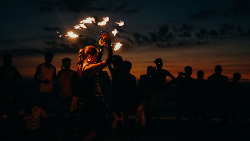 a woman performing fire dance in front of a crowd