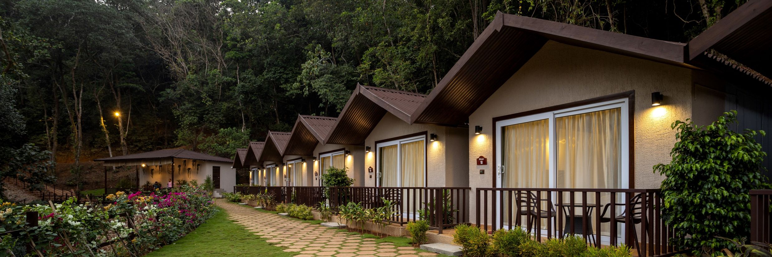 A well maintained corridor leading to the cottages illuminated by hanging lights - Stone Wood Nature Resort, Gokarna