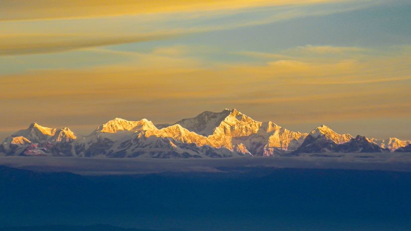 snow covered mountains with clouds above 