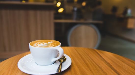 a coffee cup placed on a table with the background blurred - Raj Park Hotel, Tirupati