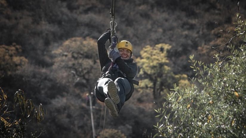 A woman ziplining with a helmet on