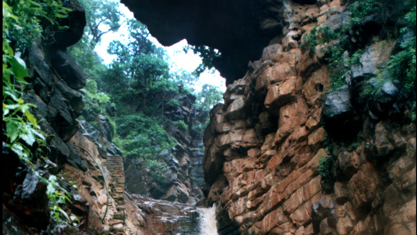 View of a waterfall, with stones on either side covered in moss