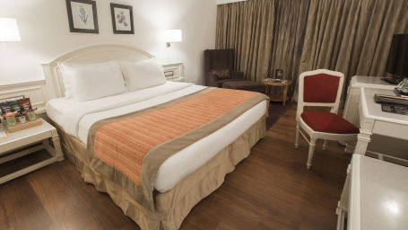 room with king size bed and wooden flooring at hotel bawa international