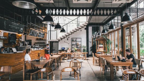 Seating arrangements inside a restaurant with the sun light shining through the windows