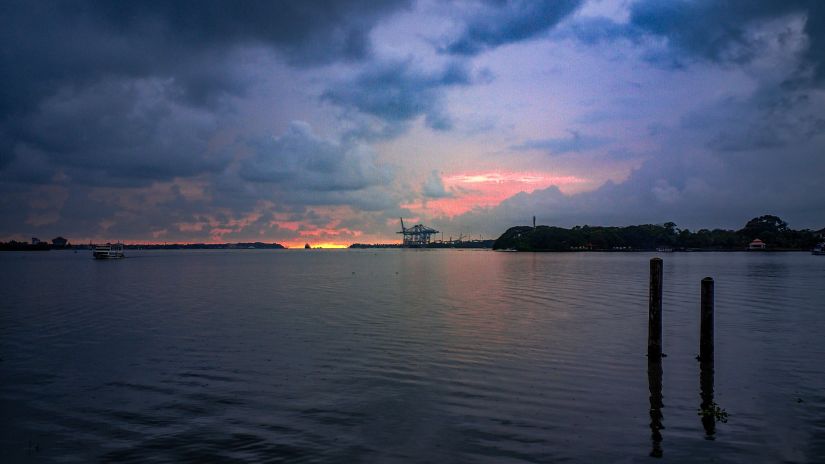 setting sun amidst cloudy skies over a lake