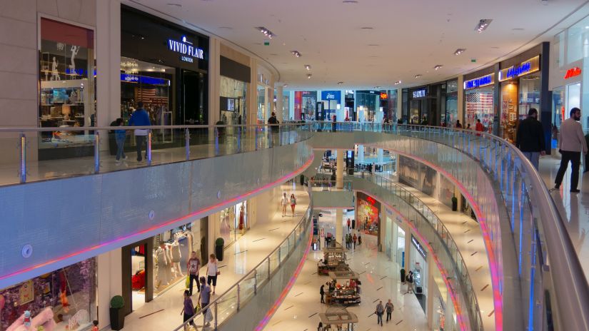 view of a mall with escalators and shops 