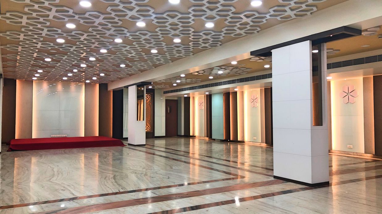 an empty Banquet Hall in Tirupati with many lights switched on - Raj Park Hotel, Tirupati