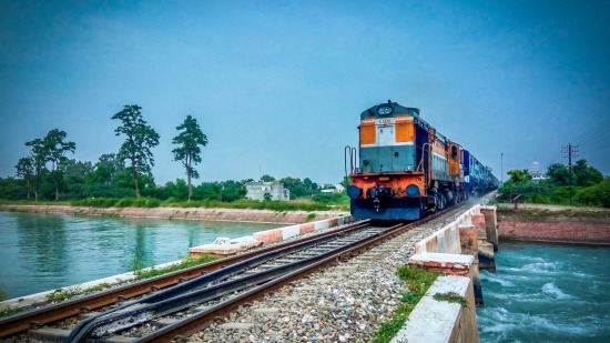 train crossing a short bridge across a river