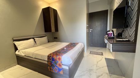 A hotel bedroom with a large bed, a television and a cupboard - VITS Select Kharadi, Pune