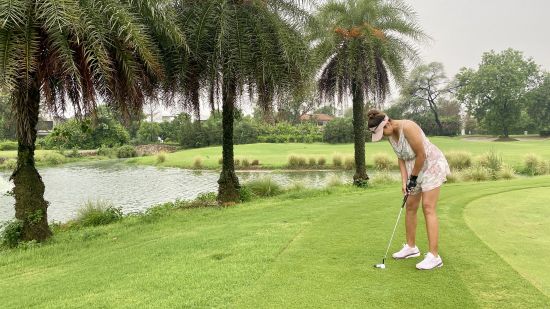 alt-text a woman playing golf at Karma Lakelands - Golf Course - Gurgaon - 14