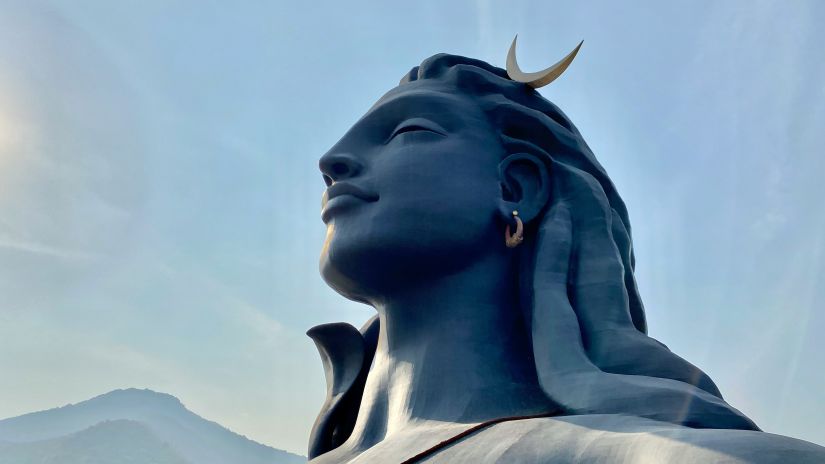 an overview of the statue of Adiyogi Shiva with a mountain in the background