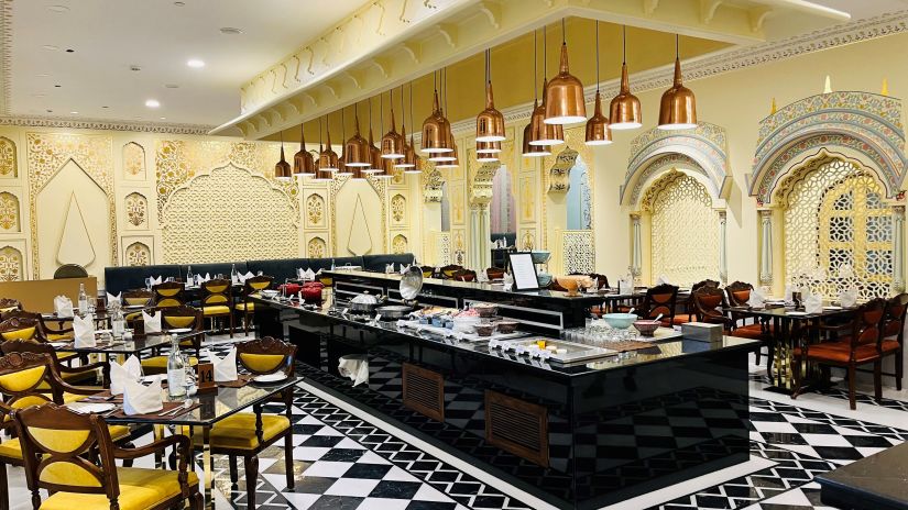 a view of a buffet counter in the centre with seating arrangements on either side at a restaurant in Heritage village resort & spa, manesar