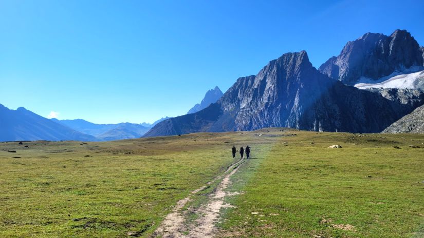 a group of trekkers trekking towards a mountain on a trekking trail