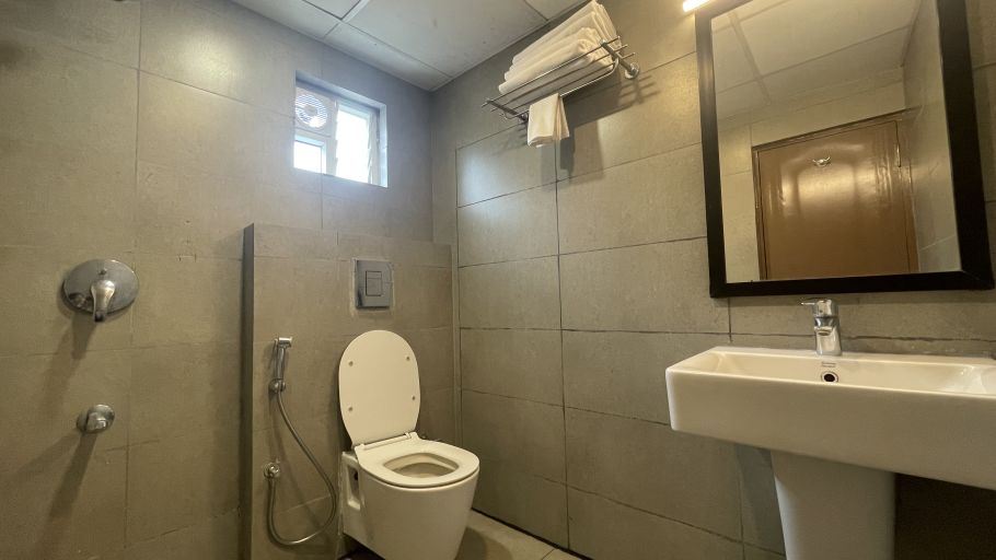 Image of a toilet and a washbasin in the washroom at Sanctum Suites Richmond Road Bangalore