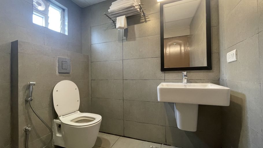 Image of a toilet and a washbasin in the washroom at Sanctum Suites Richmond Road Bangalore