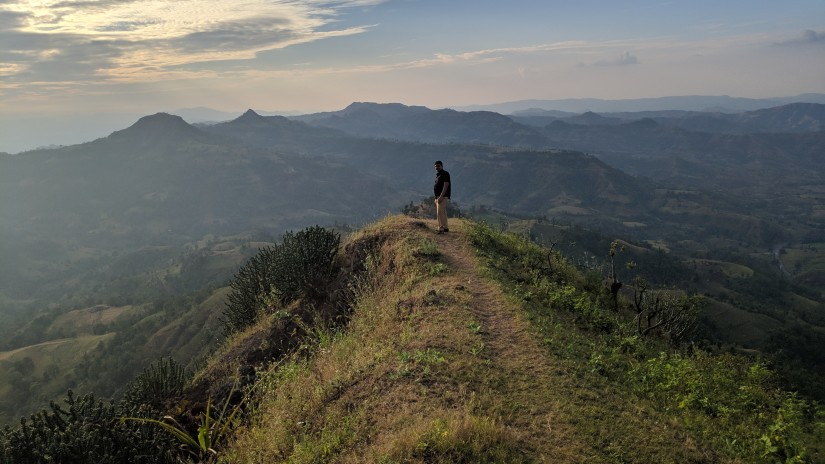 person standing on summit of hill