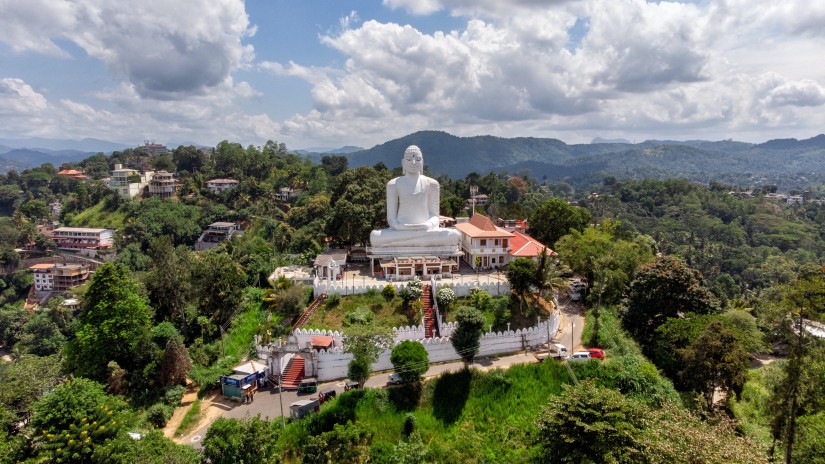 a white statue of Buddha on top of a building