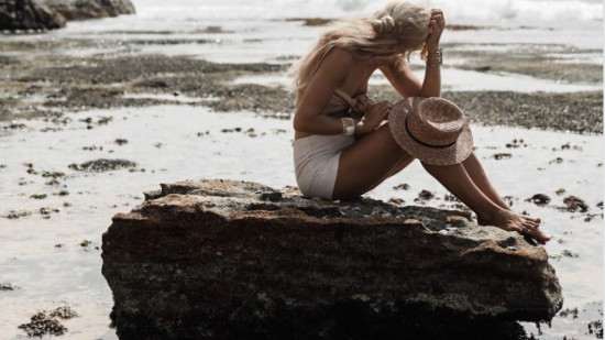 person sitting on rock at beach