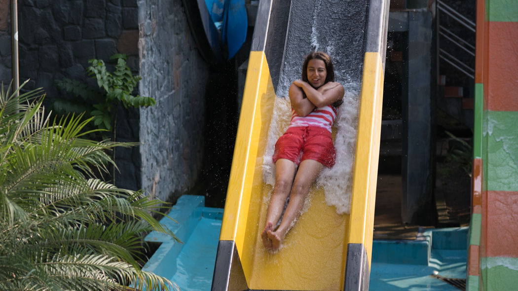 woman sliding down a watery slide