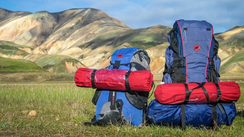 backpacks resting on grass with hills in the background