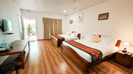 twin bed deluxe room with wooden flooring leading to the seating area4 - Ibex Stays & Trails, Valparai (Mistly)